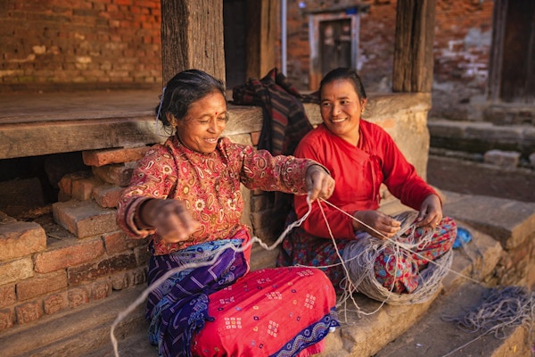 To nepalske kvinner som spinner ull foran hjemmet sitt i Bhaktapur, Kathmandudalen i Nepal.