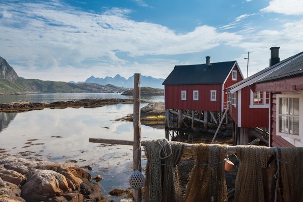 Typisk rød rorbu-fiskehytte i Svolvær i Lofoten, Norge, opplyst av midnattssolen