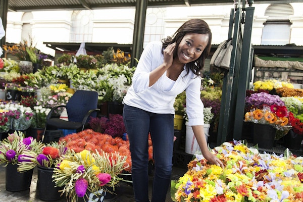 Afrikanske kvinner ser på kameraet i et blomstermarked. Cape Town, Sør-Afrika