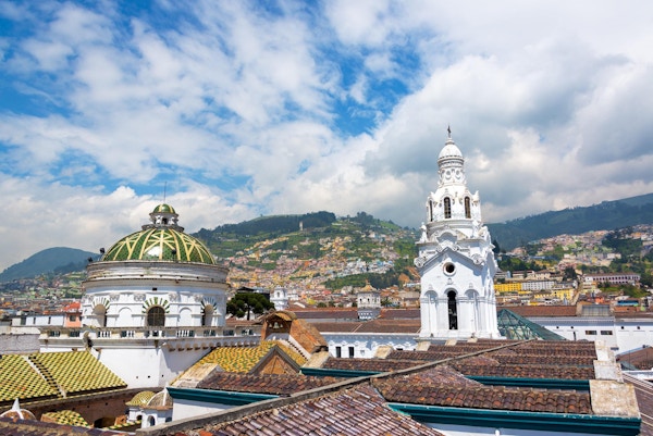 Utsikt fra taket på katedralen med befolkningstette høyder som ligger synlige i bakgrunnen i det historiske kolonisenteret Quito, Ecuador