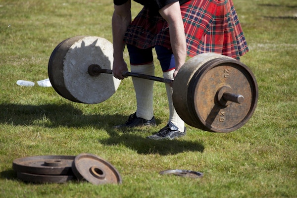 En skotsk mann som løfter "Stones of Density" - en utfordring for kraftkarene på et skotsk Highland Games-arrangement!