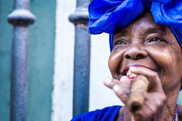 Portett av en afrikansk- cubansk kvinne som røyker en sigar i Havana, Cuba