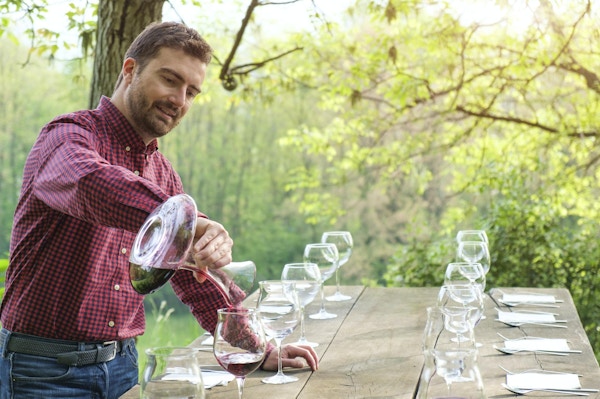 Vinsmaker og vinglass på et trebord utendørs på landsbygda