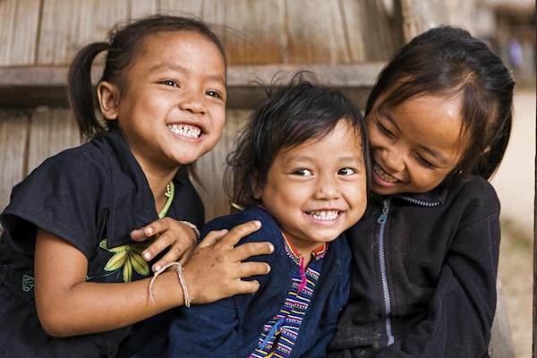 Tre små jenter som har det gøy i landsbyen i Nord-Laos.