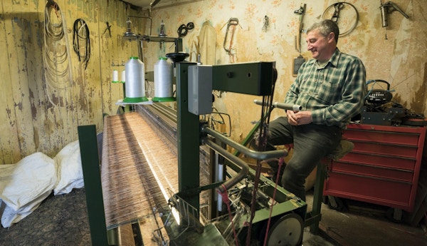 Harris Tweed produseres for hånd etter gammel oppskrift. En mann som jobber på sin fotdrevne vevstol.