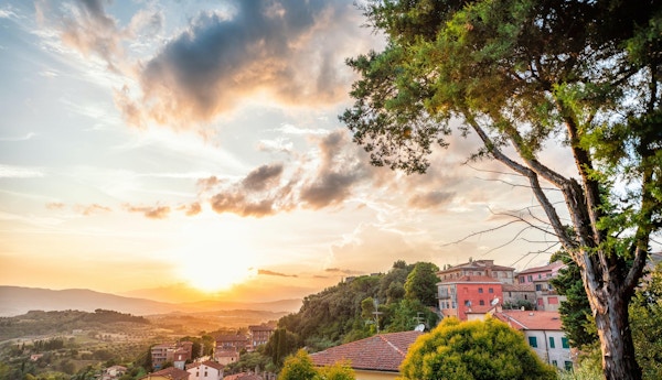 Chiusi solnedgangskveld i Umbria, Italia med takhus på fjellandskap bølgende åser og fargerik pittoreske bybildesol