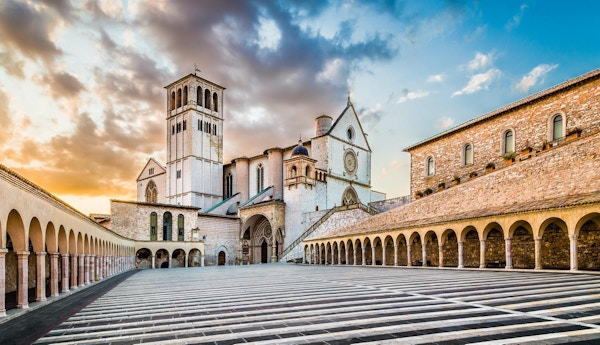 Berømte basilikaen St. Francis of Assisi (Basilica Papale di San Francesco) med Nedre Plaza ved solnedgang i Assisi, Umbria, Italia.