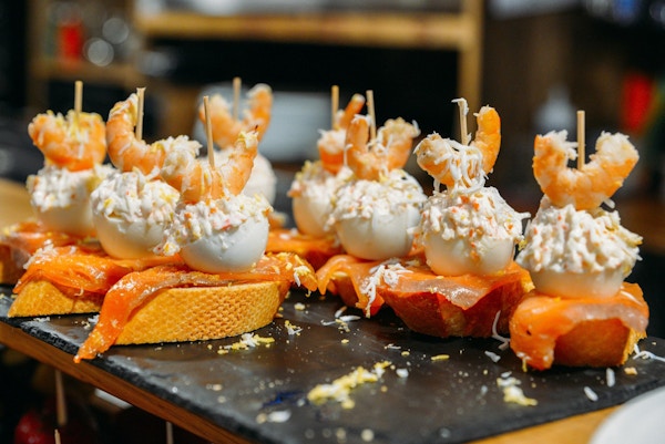 Spanske tapas kalt pintxos fra Baskerlandet serveres på en bardisk i en restaurant i San Sebastian, Spania