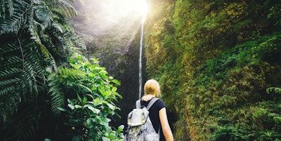 Ung kvinne som nyter fossen Caldeiré Verde mens hun vandretur på Madeira.
