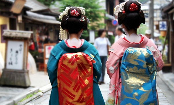 Geisha-jenter i den tradisjonelle japanske nasjonaldrakten.Bilden er tagen bakra.