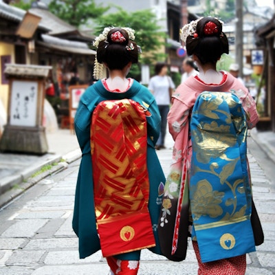 Geisha-jenter i den tradisjonelle japanske nasjonaldrakten.Bilden er tagen bakra.