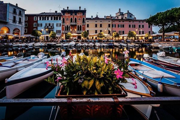 Blå time utsikt over Desenzano del Garda marina med åpne restauranter. Bilde tatt 20. august 2021 i Desenzano del Garda, Brescia-provinsen, Lombardia, Italia.