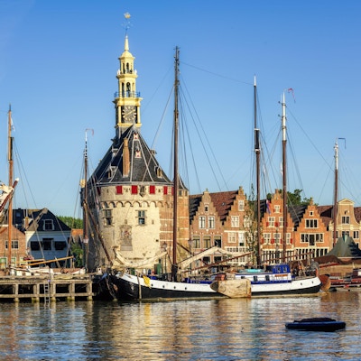 Historisk tårn, hus og båter i havnen i byen Hoorn.