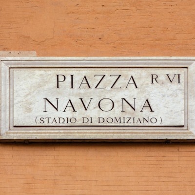 Marmortegn på Piazza Navona, Roma, Italia, også kjent som 'Stadio di Domiziano'. Det tradisjonelle skiltet er på en oransje colore vegg.
