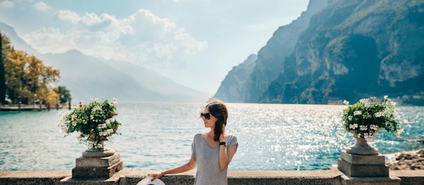 Ung vakker kvinne som slapper av på pittoreske Gardasjøen. Feriekonsept