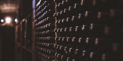En mørk vinkjeller med hundrevis av vinflasker stablet i en vegghylle