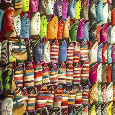 Fargerike marokkanske tøfler som henger på en vegg