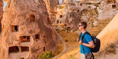 Turist som går langs grottesteiner i Cappadocia, en historisk region i Sentrale Anatolia, Tyrkia