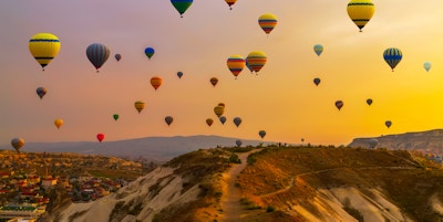 Luftballonger som lander i et fjell Cappadocia Goreme nasjonalpark, Tyrkia.