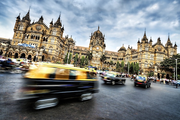 Kjøretøyer i bevegelse foran Chhatrapati Shivaji Terminus i Mumbai, India.