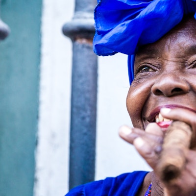 Portett av en afrikansk- cubansk kvinne som røyker en sigar i Havana, Cuba
