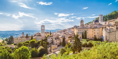 Oversiktsbilde av steinby i en grønn skråning. Assisi, en vakker og historisk liten by.
