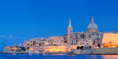 Havnen og St. Pauls anglikanske katedral og karmelittkirken i Valetta, Malta i skumringen.