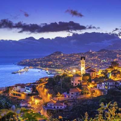 Forhøyet utsikt over distriktet og bybildet, havnen og fjellene i Funchal på den portugisiske øya Madeira.