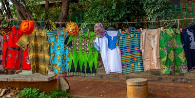 Dette bildet viser tradisjonelle afrikanske kuriositeter og klær som henger. Bildet er tatt i johannesburg på dagtid og i mars måned 2019. Pic viser fargerike afrikanske kuriositeter.