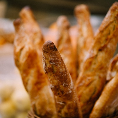 Rader med ferske, bakte franske brød klare til å selges i bakerikurv