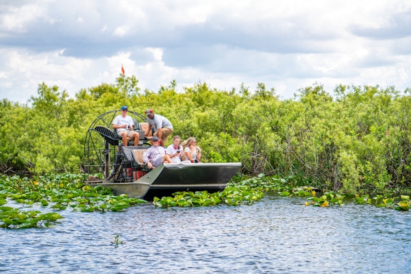 Fotografi av en gruppe turister i en luftputefartøy i våtmarkene i Everglades nasjonalpark, Florida, USA