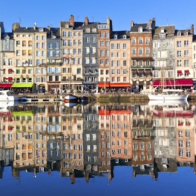 Honfleur havn i Normandie, Frankrike. Fargelegg hus og deres refleksjon i vann.