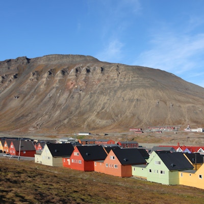 Hus i rekker i ulike pastellfarger som har fjellet i bakgrunnen