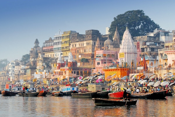Indisk by med mange båter på elva og fargerike hus.