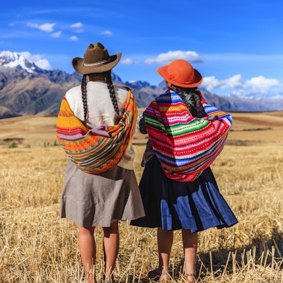 Peruvianske kvinner i nasjonale klesdrakter ved foten av Andesfjellene.