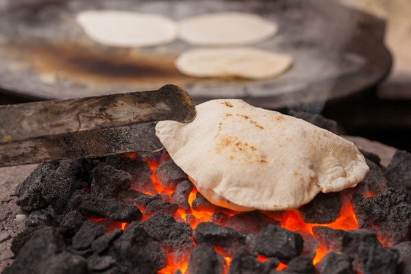 En roti (indisk flatbrød) som lager mat på kull.