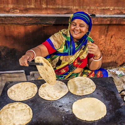 Indisk gateselger som tilbereder mat - chapatti, flatbrød, Jaipur - Den rosa byen, Rajasthan, India. Jaipur er kjent som den rosa byen på grunn av fargen på steinen som utelukkende ble brukt til konstruksjon av alle strukturer.