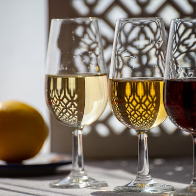 Glass med kald tørr fino og søt krem sherry forsterket vin i sommersollys, andalusisk stil interiør på bakgrunn