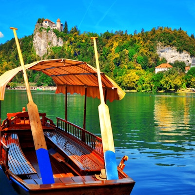Tradisjonell Pletna-båt ved innsjøen Bled. En båt som frakter turister til øya der kirken Assumption of Maria befinner seg. I bakgrunnen er det berømte gamle slottet på stupet.Slovenia