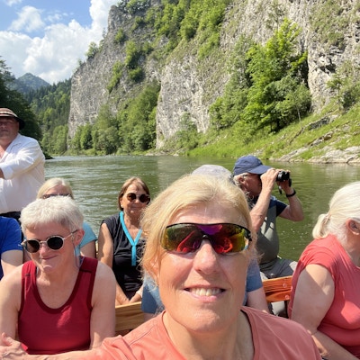 Selfie av dame med folk i bakgrunnen på tur med flåte i elva.