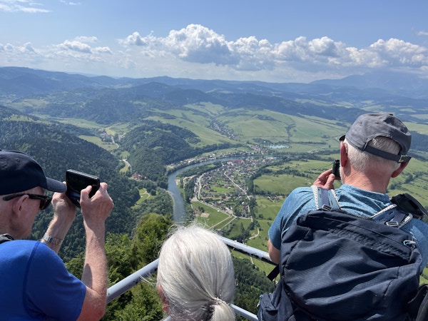 Folk fotograferer elv fra fjelltopp.