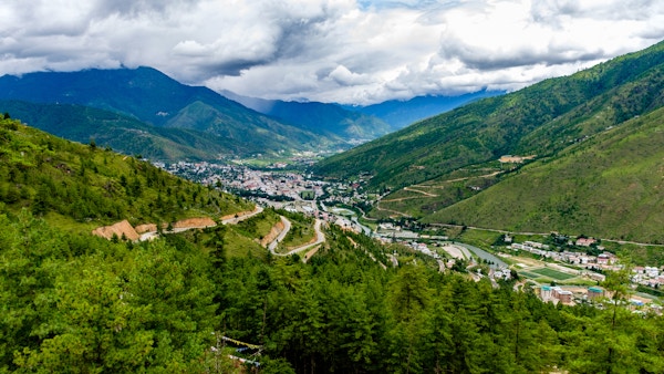 Den svingete bakkeveien og flyfotoet over Thimphu-byen i Bhutan - Thimphu er hovedstaden og den største byen i Bhutan.