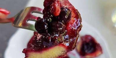 En bit av en dessert med kirsebær inni på en gaffel