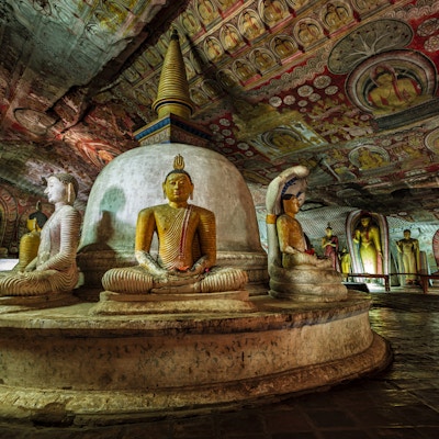 Buddha-statue inne i Dambulla-huletempelet, Sri Lanka. Dambulla grottetempel, også kjent som Golden Temple of Dambulla, er et verdensarvsted på Sri Lanka, som ligger i den sentrale delen av landet. Dette stedet ligger 148 km øst for Colombo og 72 km nord for Kandy. Det er det største og best bevarte huletempelkomplekset på Sri Lanka. Dette tempelkomplekset dateres tilbake til det første århundre f.Kr. Det er mer enn 80 dokumenterte grotter i området rundt. De viktigste attraksjonene er spredt over 5 huler, som inneholder statuer og malerier. Disse maleriene og statuene er relatert til Lord Buddha og hans liv. Det er totalt 153 Buddha-statuer, 3 statuer av srilankanske konger og 4 statuer av guder og gudinner.