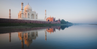 En vakker soloppgang lyser siden av Taj Mahal sett fra elven Jamuna.