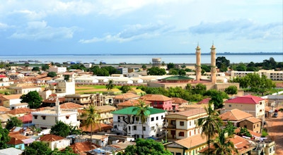 Banjul, Gambia: skyline av den lave bygningen i Gambia med elven Gambia som bakgrunn - minareter av kong Fahad-moskeen til høyre