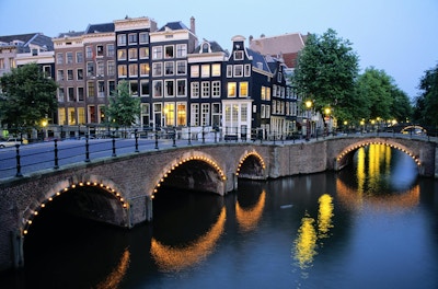 Bro over kanalen i skumringen, Amsterdam, Nederland