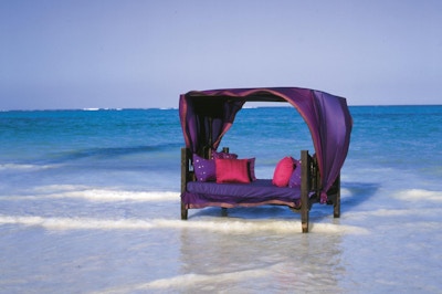 Sittemøbel ute i havet med Zanzibar med røde og lilla puter og overtrekk