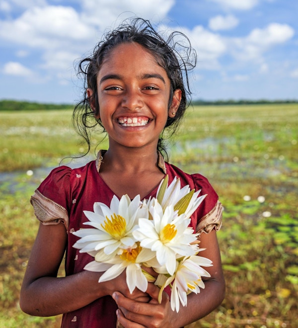 Sri Lankesisk liten jente med lotusblomster i en innsjø nær Sigiriya, Ceylon.