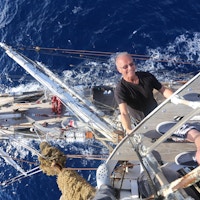 En mann som henger i masten på et skip